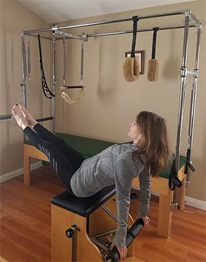 woman performing exercises on the pilates chair